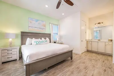 a bedroom with a large bed and a bathroom at Inviting Cottage Near Disney With Margaritaville Resort & Island H2O Access - 8009St in Orlando