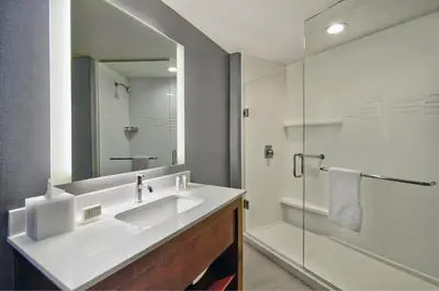 a white bathroom with a sink and a shower at Residence Inn by Marriott Orlando at FLAMINGO CROSSINGS Town Center in Orlando