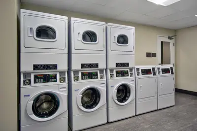 a row of washers and dryers in a laundry room at Residence Inn by Marriott Orlando at FLAMINGO CROSSINGS Town Center in Orlando