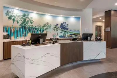 a lobby with two computers on top of a counter at Cambria Hotel Orlando Airport in Orlando