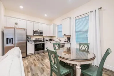 a kitchen with a table and chairs and a refrigerator at Brilliant Cottage With Private Pool Near Disney With Margaritaville Island H2O Access - 8033St in Orlando