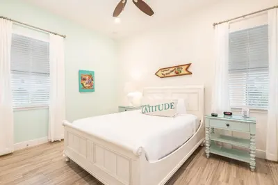 a white bedroom with a large bed and two windows at Vivid Cottage Near Disney With Margaritaville Resort & Island H2O Access - 8020Ff in Orlando