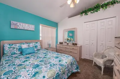 a bedroom with blue walls and a bed and a dresser at bsv_villa1607 in Orlando