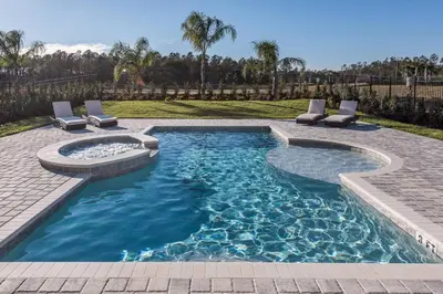 a swimming pool with a spa and lounge chairs at Encore Resort 5 Bedroom Home with Pool 2100 in Orlando