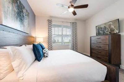a bedroom with a large bed and a ceiling fan at Encore Resort 5 Bedroom Home with Pool 2100 in Orlando