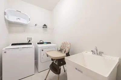 a small white kitchen with a sink and a washing machine at Encore Resort 5 Bedroom Home with Pool 2100 in Orlando