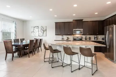 a kitchen with a large island with bar stools at Encore Resort 5 Bedroom Home with Pool 2100 in Orlando