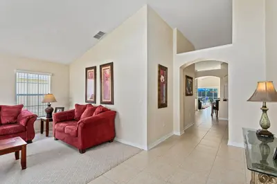 a living room with two red couches and a hallway at South Facing Pool Deck - Private Outlook - Game Room - Family Friendly - Nr Disney in Orlando