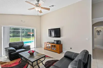 a living room with a couch and a tv at South Facing Pool Deck - Private Outlook - Game Room - Family Friendly - Nr Disney in Orlando