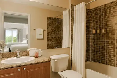 a bathroom with a toilet and a sink and a tub at The Point by Edge in Orlando