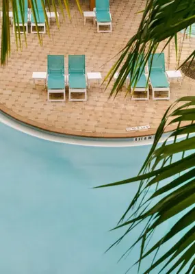 a group of blue chairs sitting on a beach at The Point by Edge in Orlando
