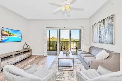 a living room with a couch and a tv at Luxury 3BR Near Disney - Pool in Orlando