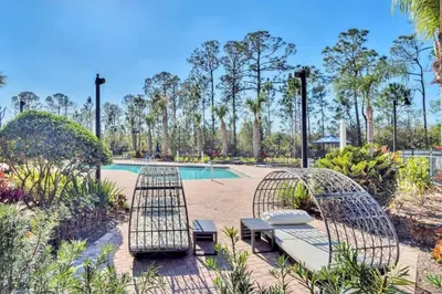a patio with two chairs and a pool at Luxury 3BR Near Disney - Pool in Orlando