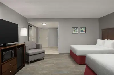 a hotel room with a bed and a tv and a chair at Hampton Inn & Suites Orlando North Altamonte Springs in Orlando