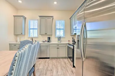a kitchen with white cabinets and a stainless steel refrigerator at Home with Hot Tub 4 Mi to Disney! in Orlando