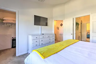 a bedroom with a large bed with a tv on the wall at Private Cocktail Pool Kissimmee Resort Retreat! in Orlando