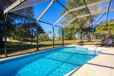 a swimming pool in a house with a pergola at 5 Bedroom 3 and half Bathroom Luxury Villa at Windsor Palms in Kissimmee