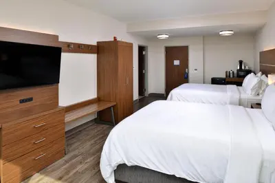 a hotel room with two beds and a flat screen tv at Holiday Inn Express Orlando - South Park by IHG in Orlando