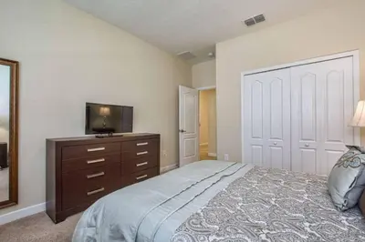 a bedroom with a bed with a television and a dresser at Sunny Escape, Pool, Spa, Resort-3509Pp in Kissimmee