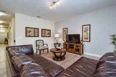 a living room with a leather couch and a television at Sunny Escape, Pool, Spa, Resort-3509Pp in Kissimmee