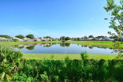 a pond in a field with houses in the background at Sunny Escape, Pool, Spa, Resort-3509Pp in Kissimmee