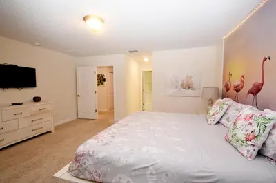 a bedroom with a large bed with pink flamingos on it at Luxury Pool Home, Spa, Grill- 1664St in Kissimmee