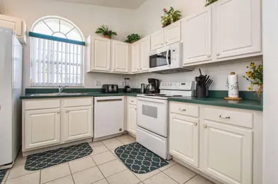 a kitchen with white cabinets and green counter tops at Indian Ridge - 4 Bedroom Pool Home- 2408Ir in Orlando