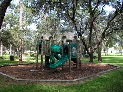 a green playground in a park with trees at Indian Ridge - 4 Bedroom Pool Home- 2408Ir in Orlando
