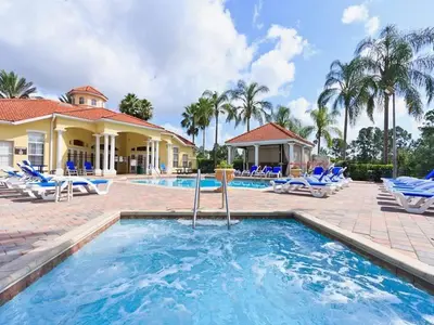 a swimming pool with blue chairs and a resort at Serene Pool & Spa, Gated Resort- 2201Em in Kissimmee