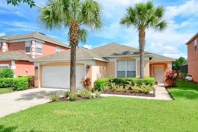 a house with two palm trees in a yard at Serene Pool & Spa, Gated Resort- 2201Em in Kissimmee