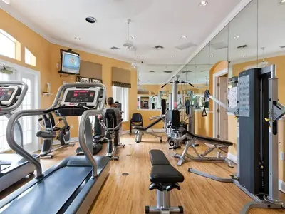 a gym with several treadmills and cardio machines at Serene Pool & Spa, Gated Resort- 2201Em in Kissimmee