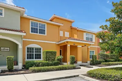 a large orange house with bushes and trees at Rare Waterfront Wspashpool, Resort -3091Pp in Kissimmee
