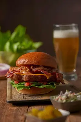 a sandwich on a table with a glass of beer at Hyatt Place Orlando Airport in Orlando