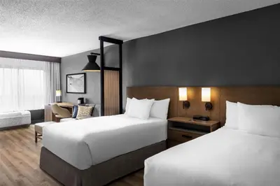 a hotel room with two beds and a chair at Hyatt Place Orlando Airport in Orlando
