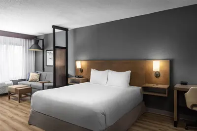 a bedroom with a large white bed and a chair at Hyatt Place Orlando Airport in Orlando