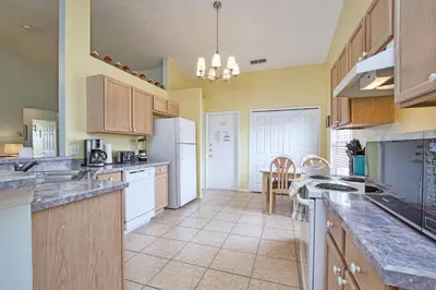 a large kitchen with white appliances and a table at Indian Ridge- 4 Bedroom Pool Home- 2405Ir in Orlando