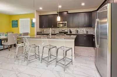 a kitchen with a island with bar stools at Comfortable Spacious-6 Bed Pool Home - 1675Str in Kissimmee