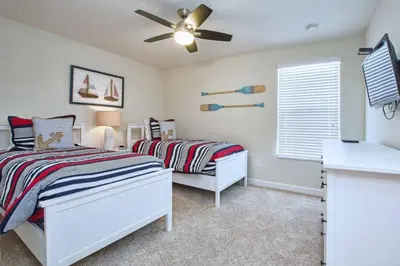 a bedroom with two beds and a ceiling fan at Comfortable Spacious-6 Bed Pool Home - 1675Str in Kissimmee