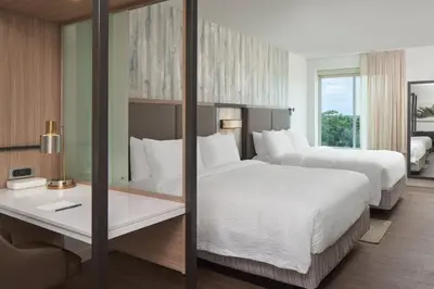 a hotel room with two beds and a desk at SpringHill Suites by Marriott Orlando Lake Nona in Orlando