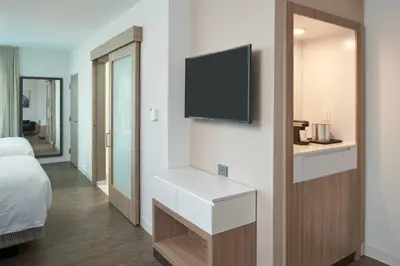 a room with a bed and a tv on a wall at SpringHill Suites by Marriott Orlando Lake Nona in Orlando