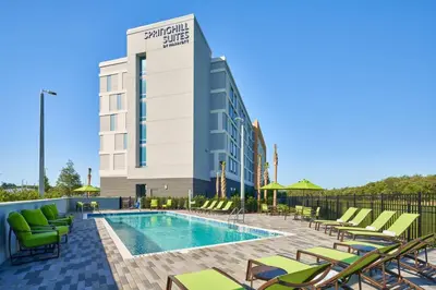 a swimming pool with lounge chairs and a hotel at SpringHill Suites by Marriott Orlando Lake Nona in Orlando