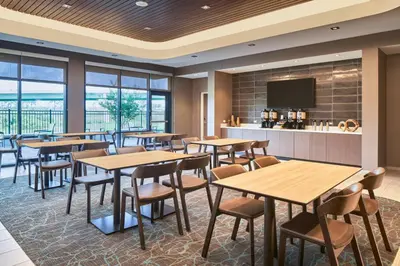 a restaurant with tables and chairs and a bar at SpringHill Suites by Marriott Orlando Lake Nona in Orlando