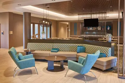 a lobby with a couch and chairs and a tv at SpringHill Suites by Marriott Orlando Lake Nona in Orlando