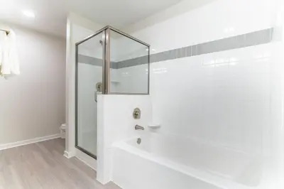 a white bathroom with a shower and a tub at 4013 Vista Cay in Orlando