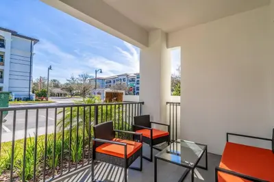 a balcony with two chairs and a glass table at 4013 Vista Cay in Orlando