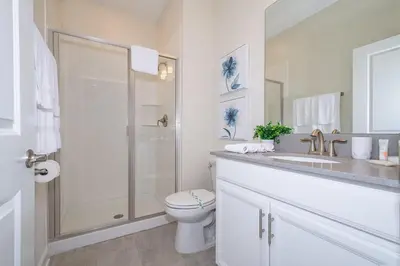 a white bathroom with a toilet and a shower at 4809AM TOWNHOUSE 4 BEDROOMS & 3 BATHROOMS + POOL in Kissimmee