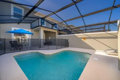 a large swimming pool in a building with a roof at 4313SL TOWNHOUSE 4 BEDROOMS & 3 BATHROOMS + POOL in Kissimmee