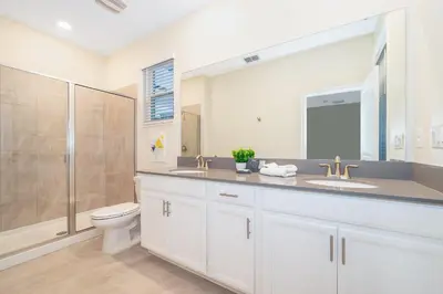 a bathroom with a toilet and a sink and a shower at 4352JP VILLA 5 BED/5 BA in Kissimmee