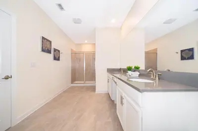 a white kitchen with a sink and a counter at 4352JP VILLA 5 BED/5 BA in Kissimmee
