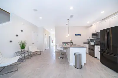 a kitchen with white cabinets and a black refrigerator at 4393MO TOWNHOUSE 5 BEDROOMS & 4 BATHROOMS + POOL in Kissimmee